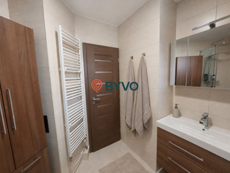Bathroom with wall-mounted cabinets, a sink, and a ladder radiator in a 4-room apartment.