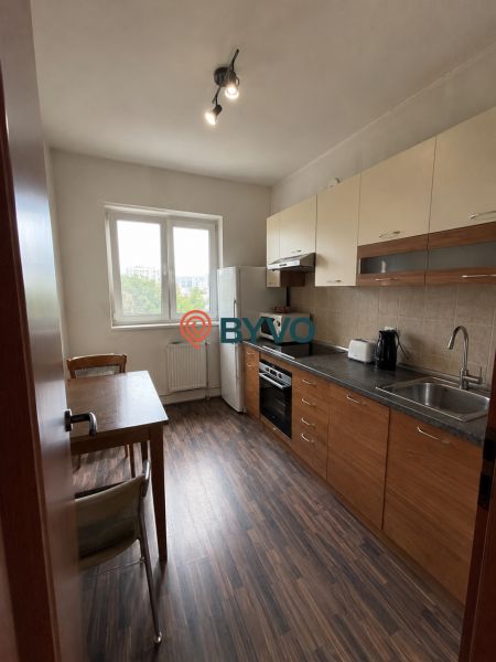 A kitchen in a 4-room apartment with a wooden decor floor and a modern kitchen unit.