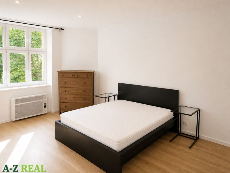 A bedroom in a 3-room apartment with a wooden decor floor, a bed, and a dresser.