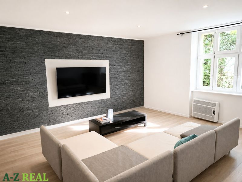 Living room in a 3-room apartment with a gray stone wall and a wooden decor floor.