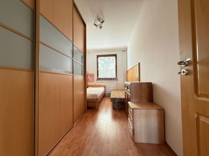 A bedroom with a wardrobe and a wooden decor floor in a 4-room apartment.