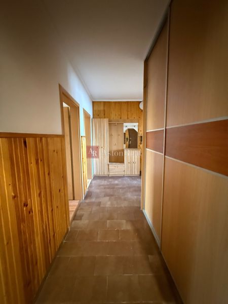A hallway in a 4-room apartment with wood paneling and built-in wardrobes.