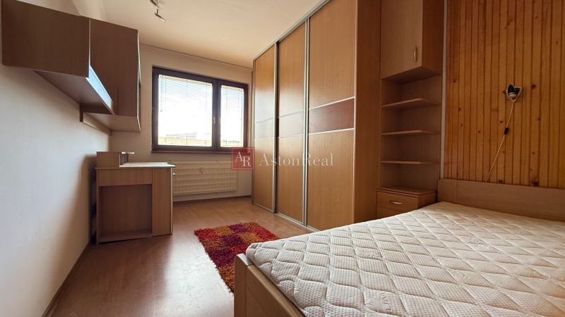 A room with a wardrobe, a wooden-decor floor, and a desk in a four-room apartment.