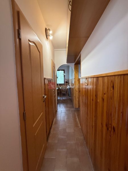 A narrow corridor with light wood paneling in a 4-room apartment.