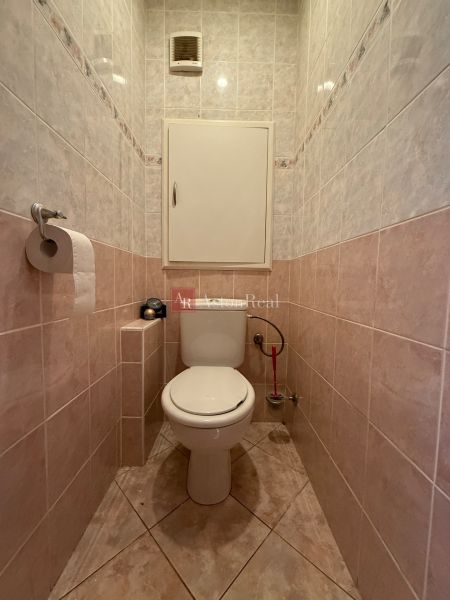 A toilet with ceramic tiles in a 4-room apartment.
