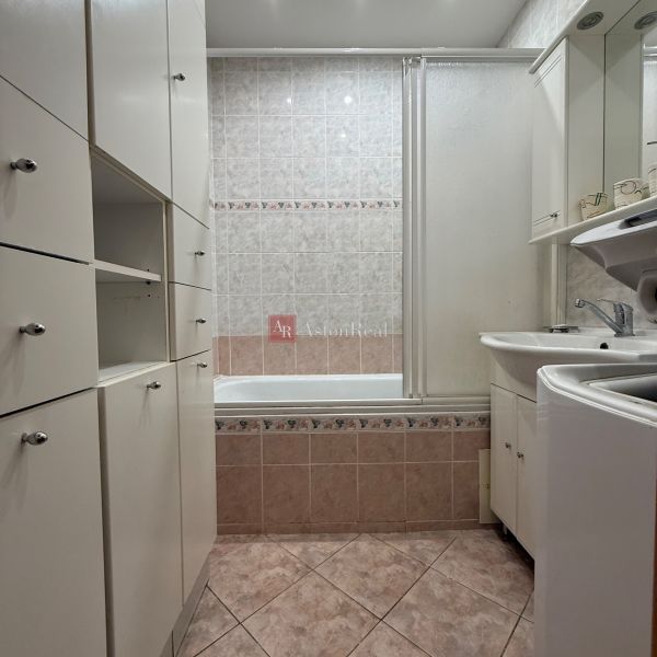 A bathroom with a bathtub and built-in cabinets in a 4-room apartment.