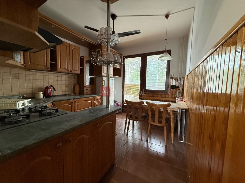 A kitchen with built-in appliances and wooden cabinets in a 4-room apartment.