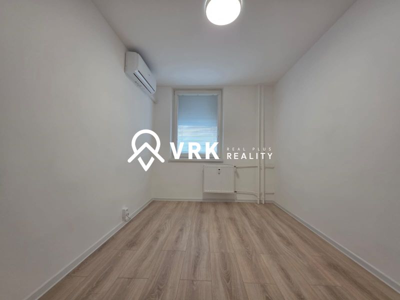 A room with air conditioning and a wooden decor floor in a 3-room apartment.