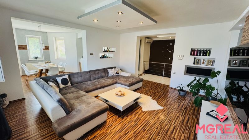 Living room in a family house with a large sofa set and a wooden decor floor.
