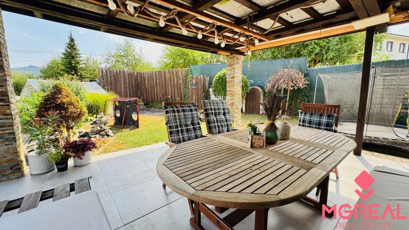 The terrace of a family house in Radobica with seating, greenery, and a view of the garden.