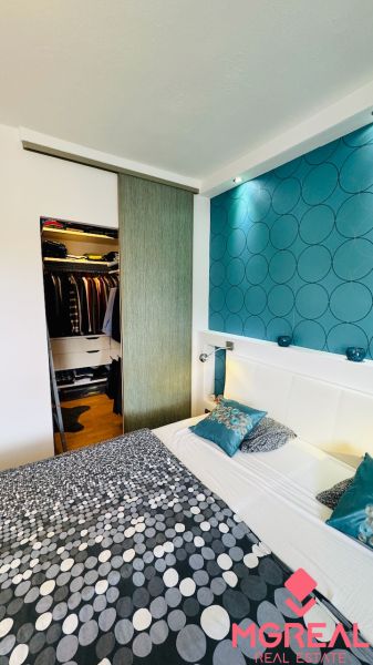 Bedroom in a family house with storage space and wallpaper with circles.
