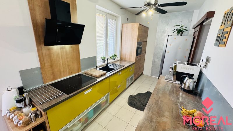 A kitchen in a family house with colorful cabinets and stylish lighting.