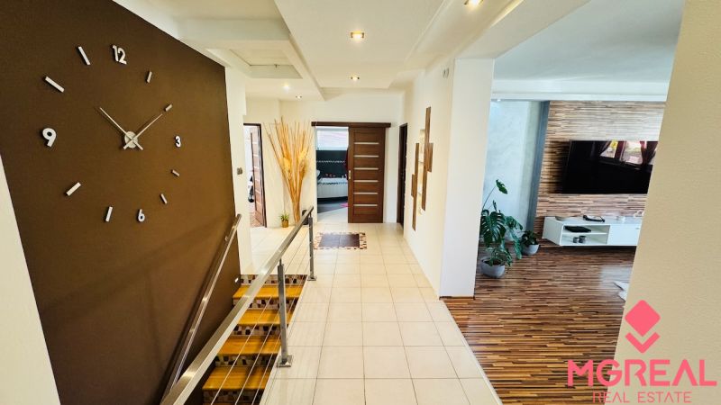 Interior of a family house with a wooden decor floor and large wall clock.