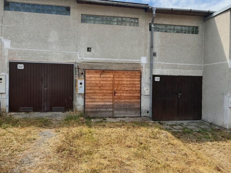 Garages on Môťová Street in Zvolen with concrete facades and wooden gates.