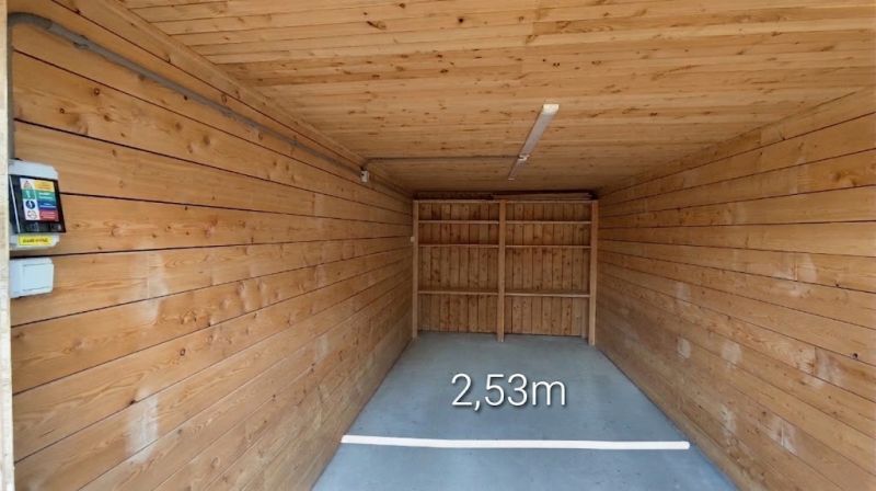 A closed space with a floor and walls with a wooden decor, width 2.53 meters.