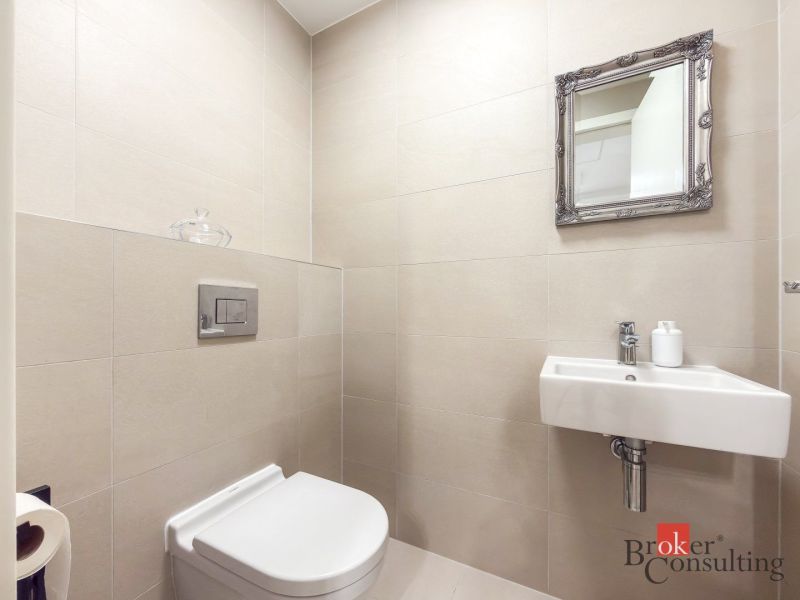 A bathroom in a 2-room apartment with a sink and a mirror on the wall.