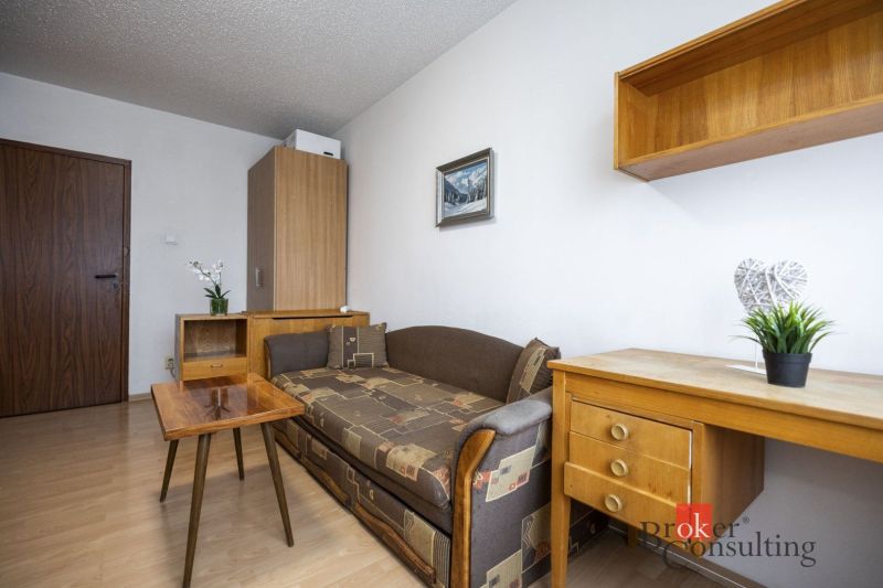A room in a 4-room apartment with a retro sofa, a table, and a desk.