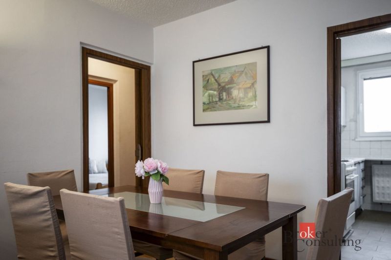 Dining room with a framed picture and a table with a vase, in a 4-room apartment.