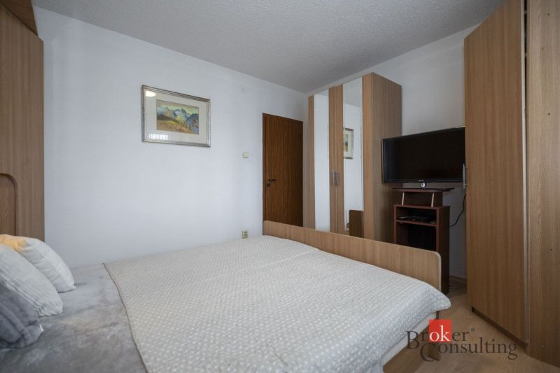 Bedroom in a 4-room apartment with a bed, wardrobe, and television.