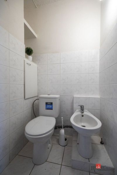 A bathroom with white tiles and sanitary ware in a 4-room apartment.
