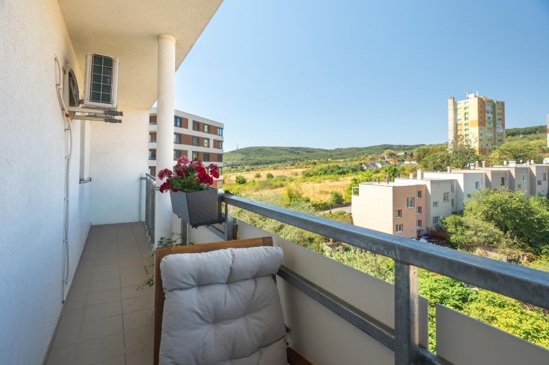 The balcony of a 3-room apartment on Sadmelijská Street in Bratislava - Rača with a view of greenery.
