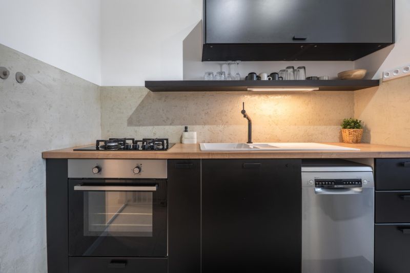 A kitchen in a 3-room apartment with a stove, dishwasher, and wooden decor on the countertop.