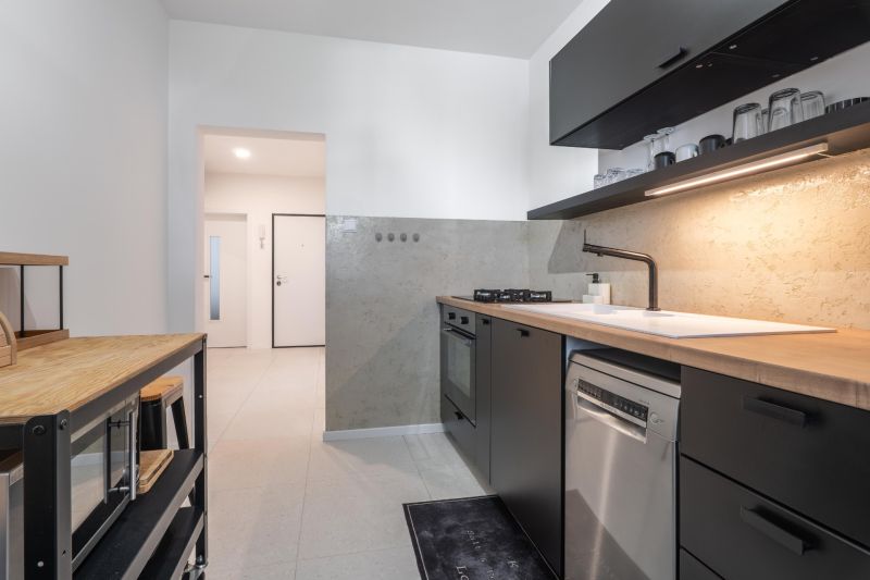 A kitchen with light walls, dark furniture, and appliances in a 3-room apartment.
