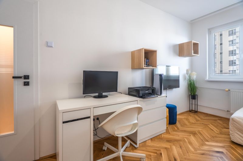 Workspace with a desk and chair in a 3-room apartment with a wooden decor floor.