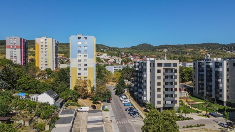Apartment buildings and greenery on Sadmelijská Street in Bratislava - Rača, clear blue sky.