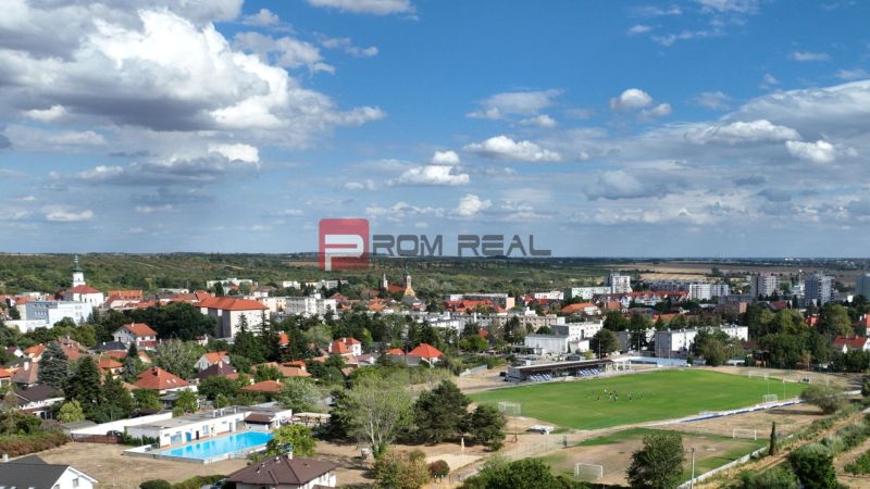 Aerial view of Modra with a football field and surrounding residential areas.