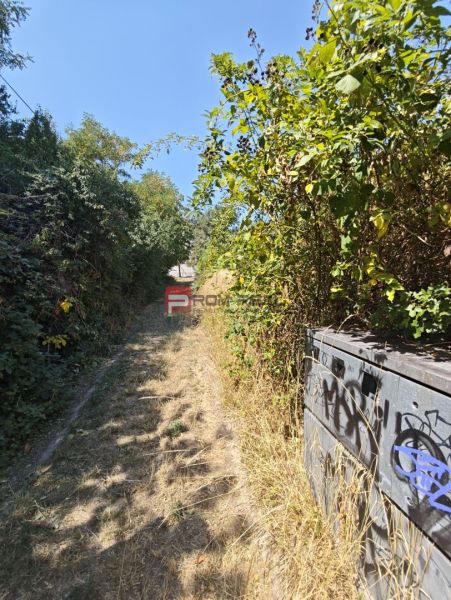 Plots - housing in Modra with an overgrown road and graffiti on the electrical box.