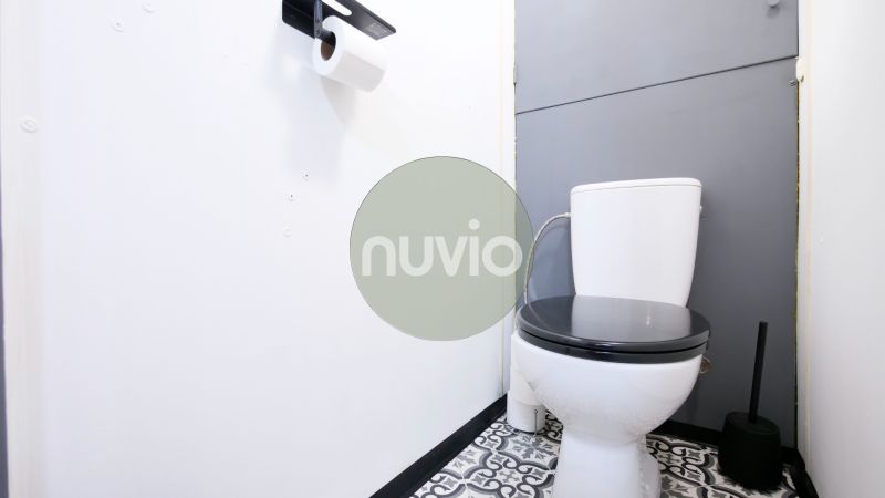 A bathroom with black and white tiles and toilet paper in a two-room apartment.