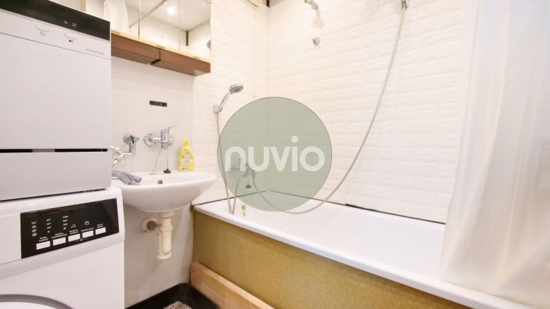 Bathroom in a 2-room apartment with a shower bath and a washing machine.