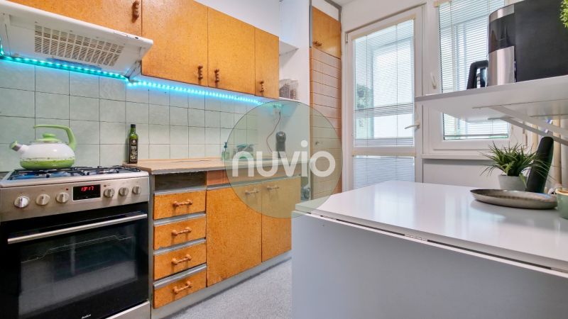 A kitchen in a 2-room apartment with a white countertop, cabinets, and a gas stove.