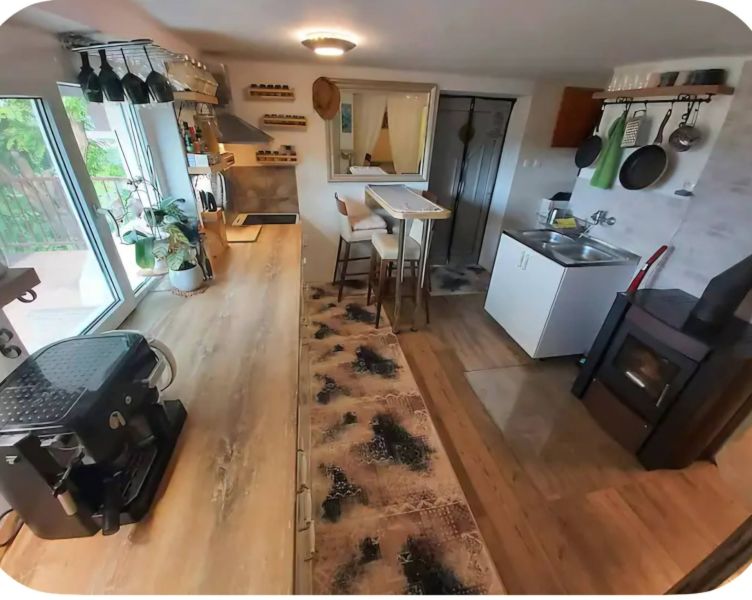 A kitchen in a family house with a wooden decor floor, view of the stove and dishes.