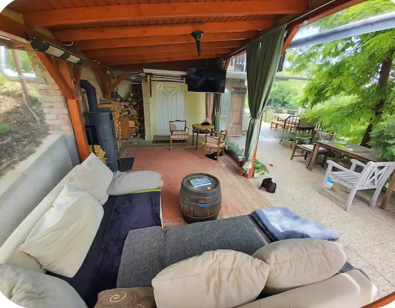 Covered terrace of a family house in Piešťany with comfortable seating and a stove.