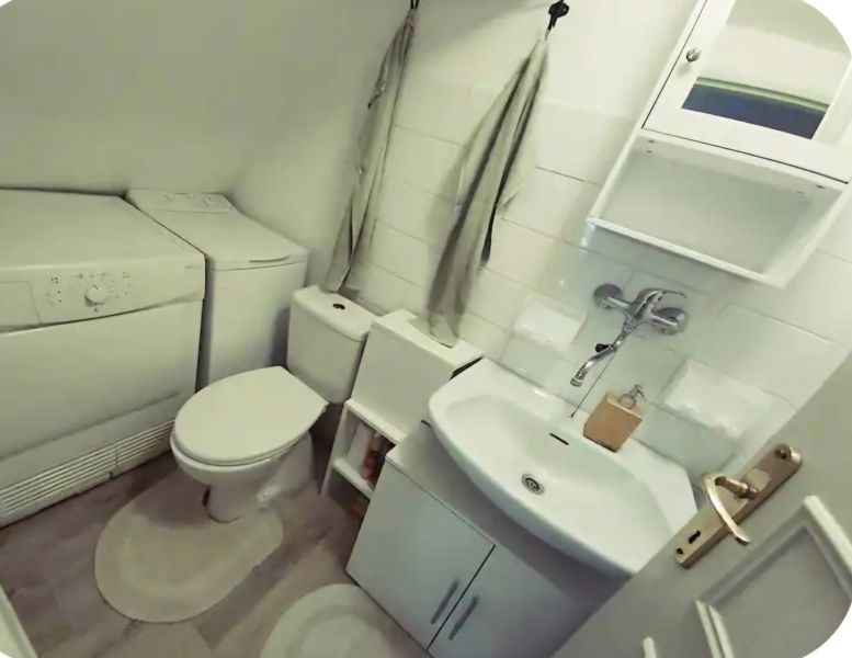 Bathroom in a family house with appliances, toilet, and sink.