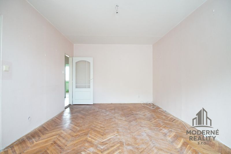 A room with a wooden decor floor in a 3-room apartment.