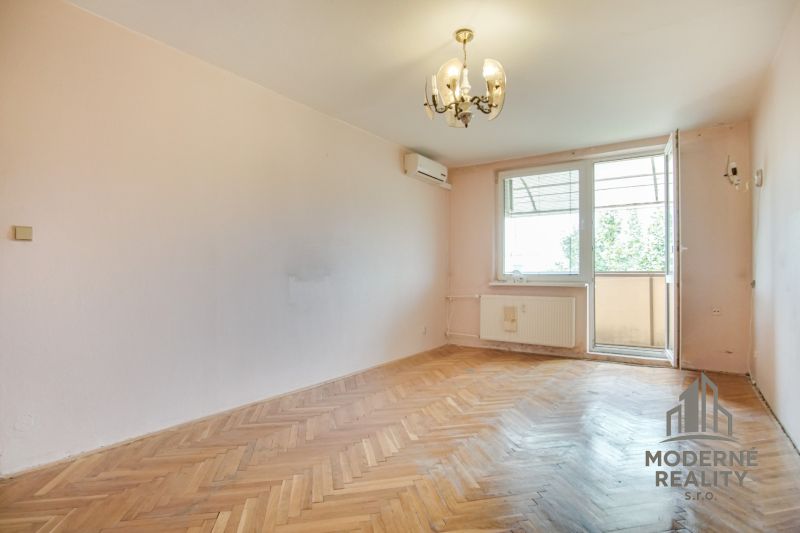 A room in a 3-room apartment with a wood-decor floor and a balcony.