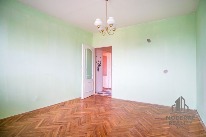A room with a wooden floor decor and green walls in a 3-room apartment.