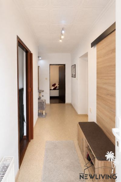 A hallway in a family house with wooden decor on the wall and simple lighting.