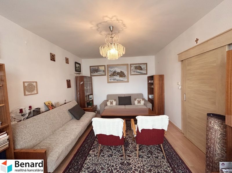 Living room in a 3-room apartment with carpets and bookshelves.