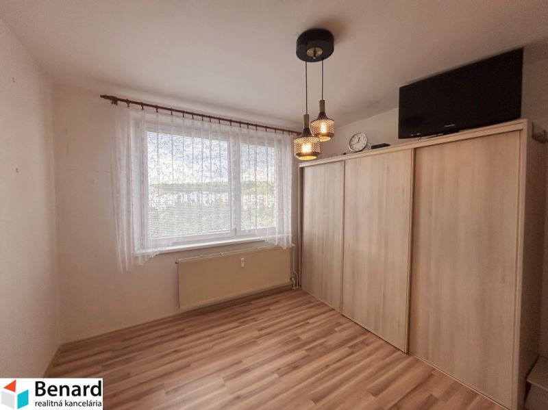 A room in a 3-room apartment with a wooden decor floor and a built-in wardrobe.