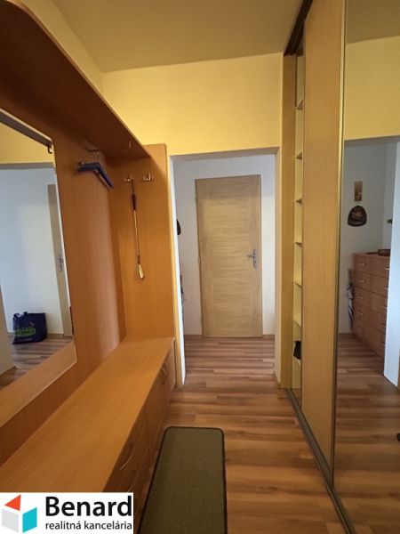 Interior of a 3-room apartment with a wooden decor floor and built-in wardrobes.