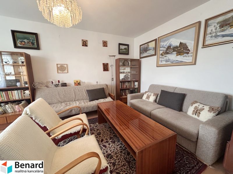 Living room in a 3-room apartment with sofas, armchairs, and paintings on the walls.