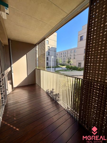 Balcony of a 2-room apartment with a wooden decor floor and a view of the courtyard.