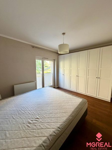 Bedroom in a 2-room apartment with a white wardrobe and a wooden decor floor.