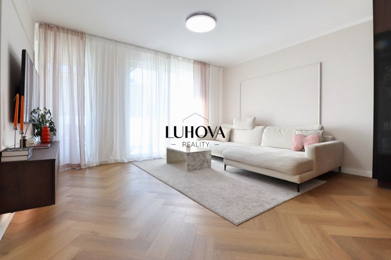 Living room in a 3-room apartment with a white sofa and a wooden decor floor.
