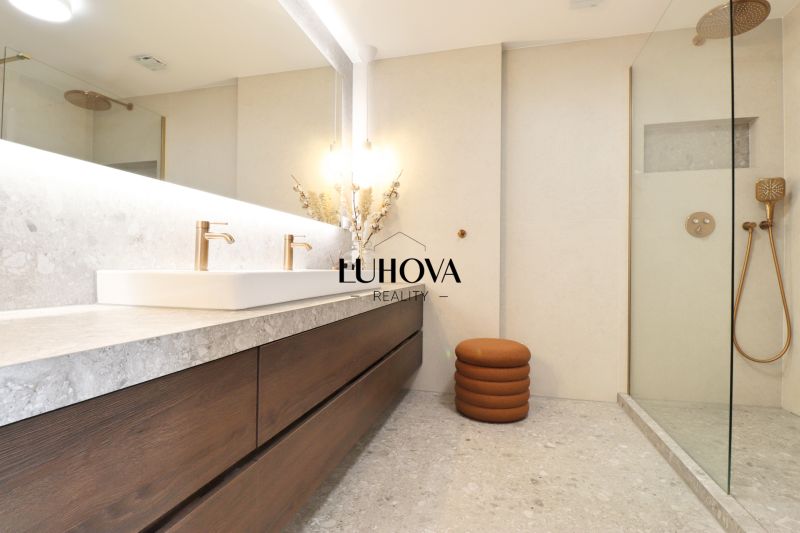 A bathroom with a double sink and a shower in a 3-room apartment.