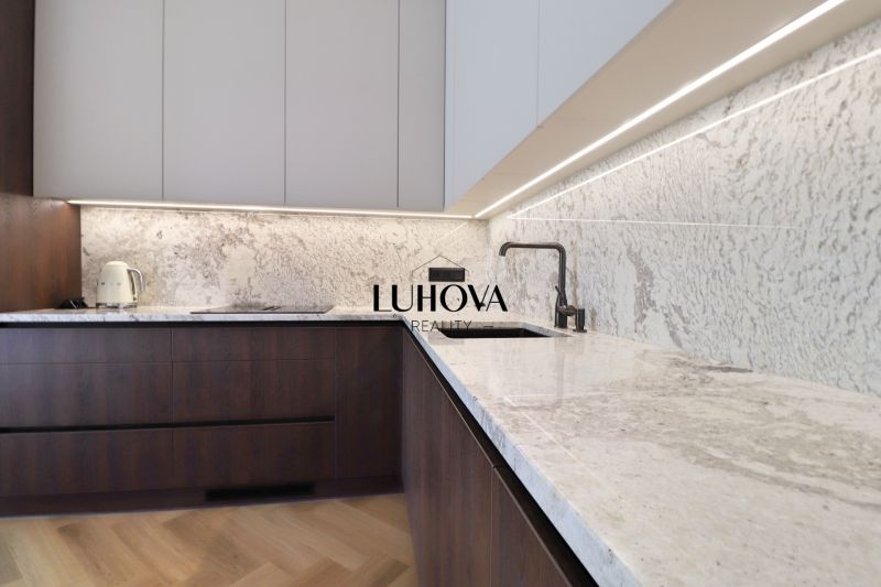A kitchen in a 3-room apartment with marble countertops and a wood-patterned floor.